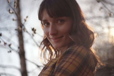 Portrait of smiling young woman by plants