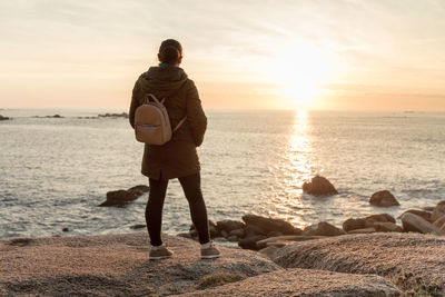 Woman on the coast watching the sunset. ribeira, spain