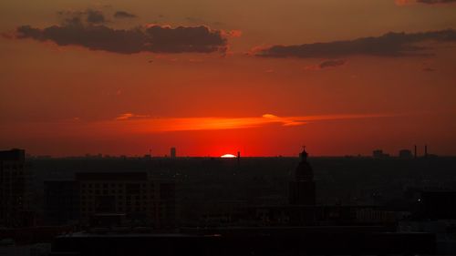 Silhouette cityscape against sky during sunset