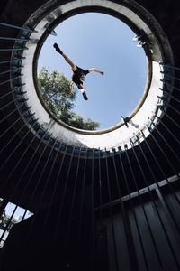 Directly below shot of man jumping over built structure