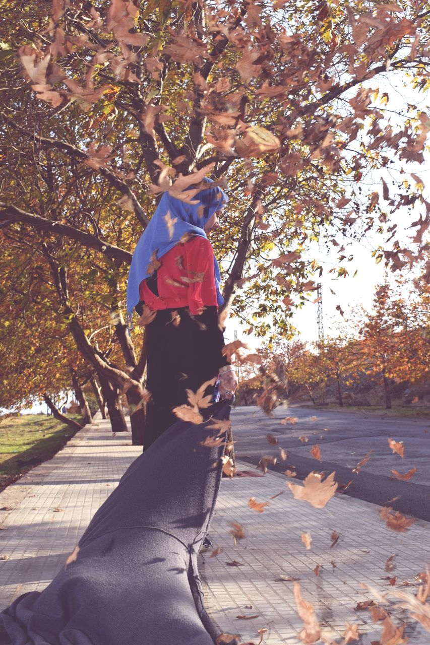 tree, autumn, real people, outdoors, leaf, day, branch, nature, leisure activity, lifestyles, full length, beauty in nature, young women, young adult, people