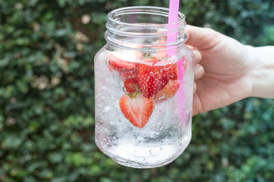 Close-up of hand holding drink in jar