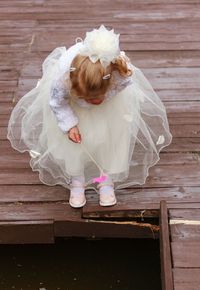 High angle view of girl in fairy costume standing on floorboard