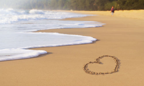 Draw a heart shape on the sandy beach in the morning. to welcome valentine's day festival.