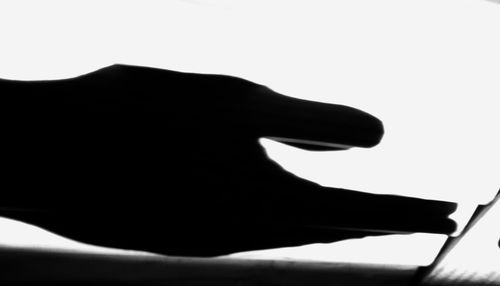 Close-up of silhouette hand against white background