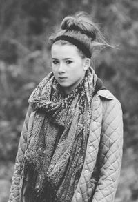 Portrait of young woman in scarf against trees