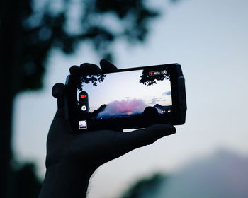 Reflection of person photographing camera on mobile phone