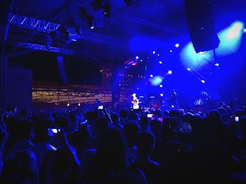 Rear view of people watching music concert at night