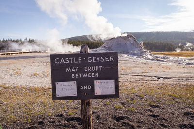 Information sign on landscape against sky