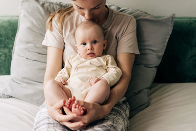 Portrait of cute baby boy lying on bed at home