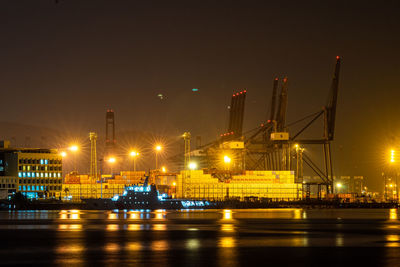 Illuminated harbor against sky at night