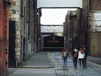 People walking on street amidst buildings in city