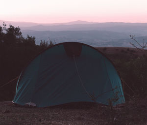 View of tent on mountain against cloudy sky