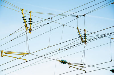 Low angle view of power cables against sky