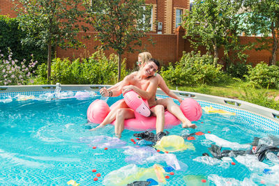 Young man sitting in swimming pool