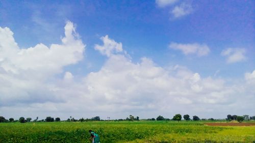 Scenic view of grassy field against cloudy sky