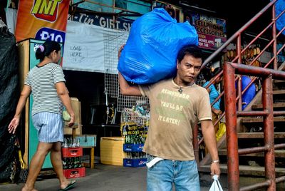 Rear view of friends standing at market in city