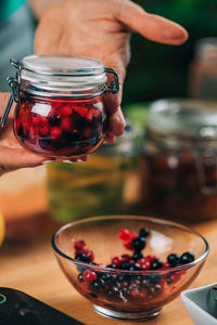 Woman holding jars with fermented fruits.