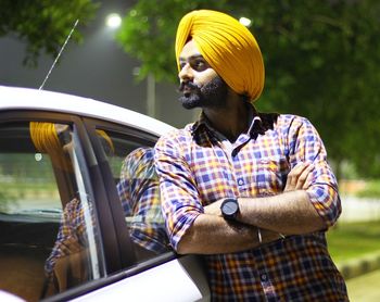 Man standing by car at night