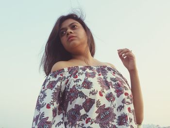 Low angle view of woman standing against wall