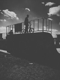 Silhouette of woman against cloudy sky