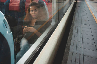 Woman sitting in train seen through window