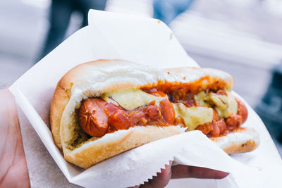 Cropped image of hand holding hot dog