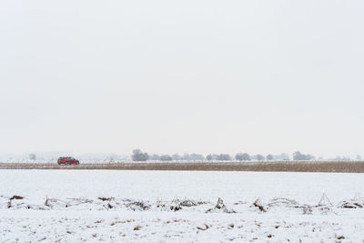 Snow covered landscape against clear sky