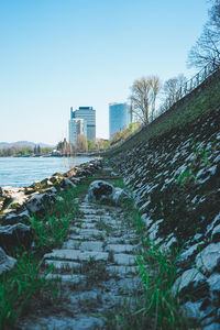 Surface level of footpath amidst buildings against sky