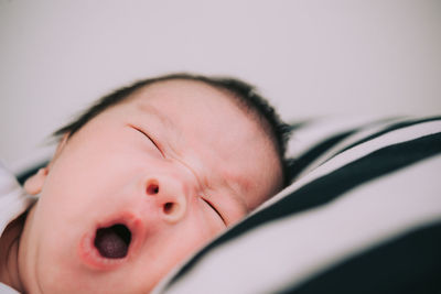 Close-up portrait of cute baby girl on bed