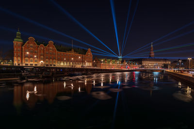 Illuminated bridge over river at night