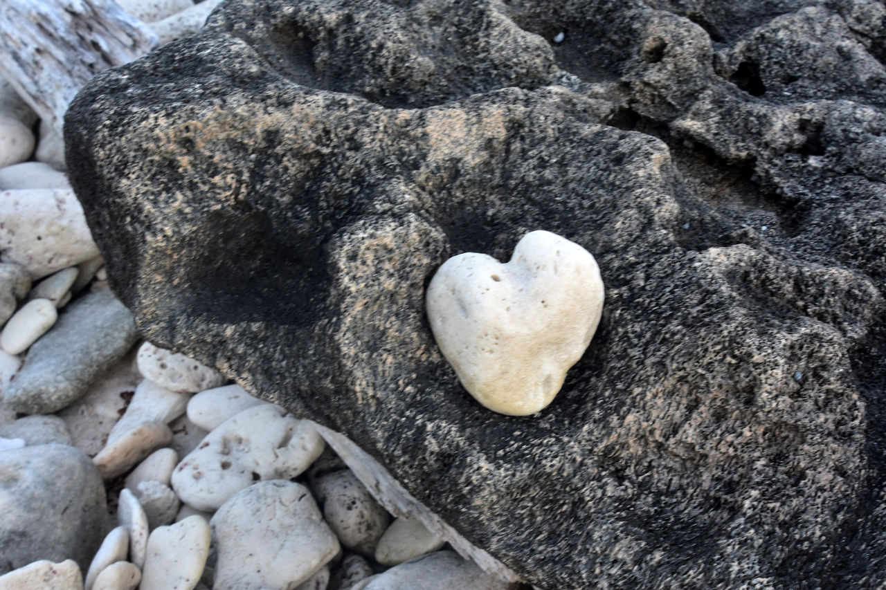 rock, heart shape, nature, land, beach, no people, love, positive emotion, day, high angle view, stone, emotion, geology, pebble, boulder, outdoors, soil, beauty in nature, sand, tranquility, textured, close-up