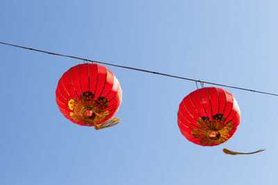 Low angle view of lanterns hanging against clear sky