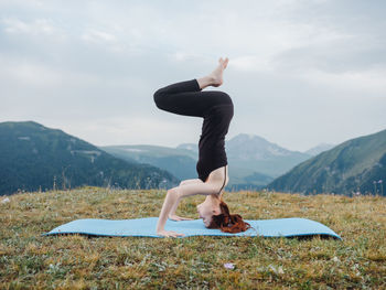 Woman with arms outstretched against mountain