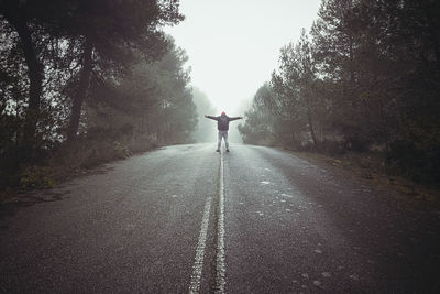 Rear view of person walking on road