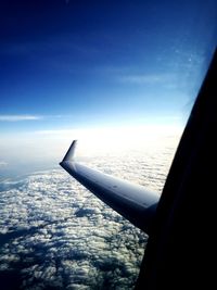 Cropped image of airplane flying over clouds