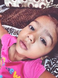 Close-up portrait of cute baby lying on bed