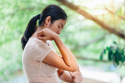 Side view of young woman looking away outdoors