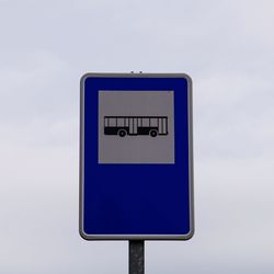 Close-up of road sign against sky