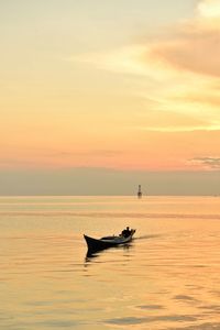 Silhouette boat in sea against sky during sunset