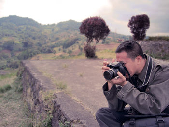 Photographer photographing on field