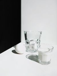 Close-up of empty glass on table against white background