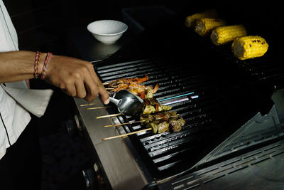 Person preparing food on barbecue grill