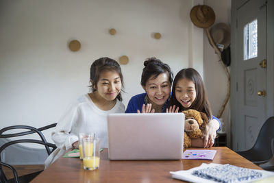 Happy family doing video call with laptop at home