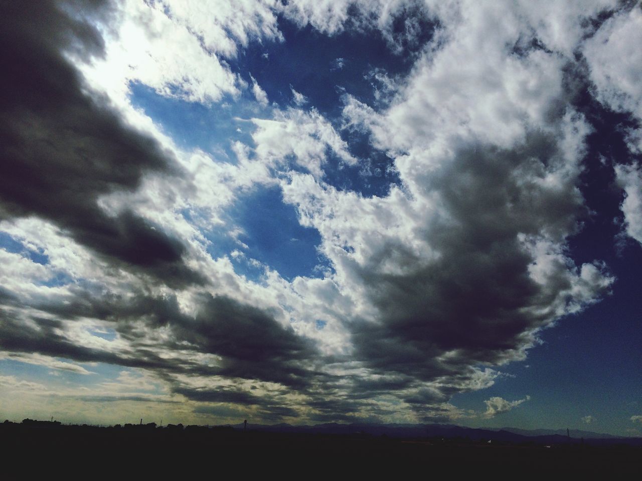 sky, cloud - sky, cloudy, tranquility, tranquil scene, scenics, beauty in nature, low angle view, cloud, nature, cloudscape, silhouette, weather, overcast, idyllic, landscape, storm cloud, outdoors, dramatic sky, dusk