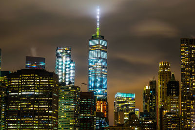 Illuminated buildings in city against sky at night