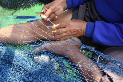 Low section of man holding fishing net