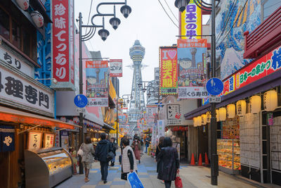 People walking on city street amidst buildings