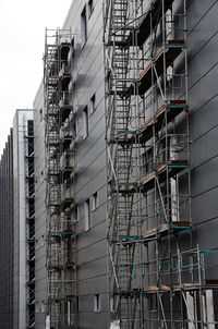 Low angle view of buildings in city with scaffolding