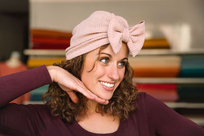 Joyful fashion designer playfully posing with a handmade pink bow headband